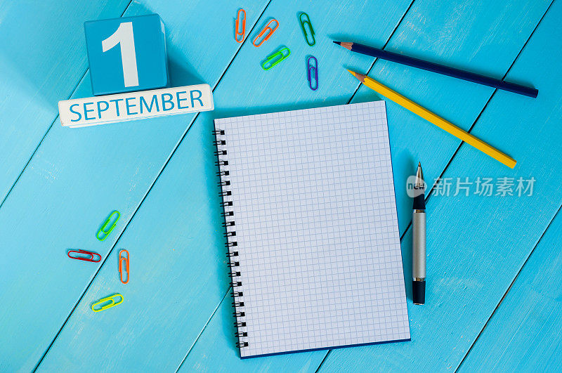 9月1日。月的第一天，木制的彩色日历在蓝色的背景上。秋天的时间。文本的空白。回到学校