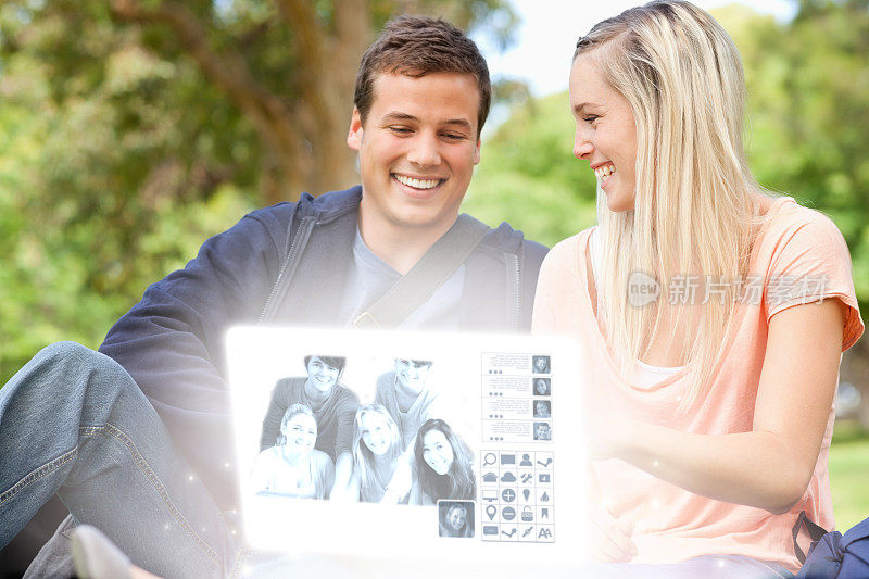微笑的年轻夫妇在数字界面上一起看照片
