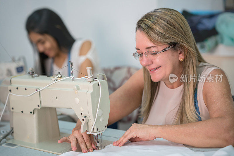 缝纫女工在缝纫车间用缝纫机缝纫的女裁缝