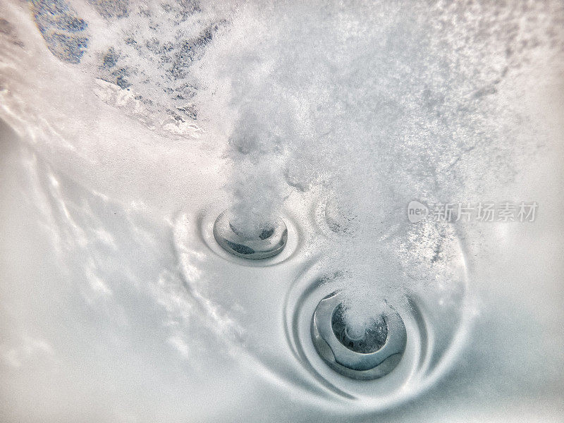 水下的喷射器在温泉热水浴缸与泡沫