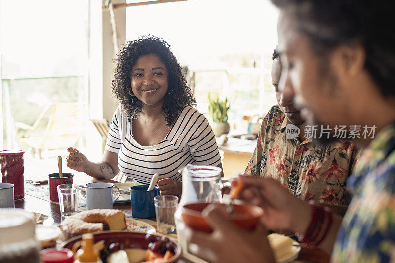 年轻的巴西女人微笑着和朋友吃早午餐