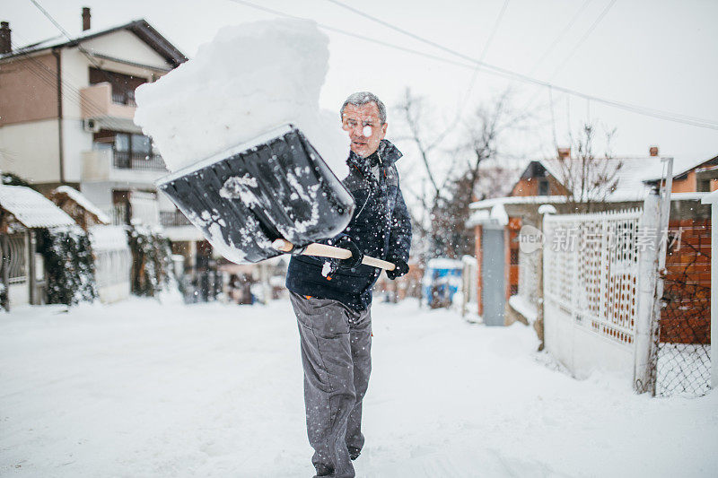 有人用雪铲清扫人行道