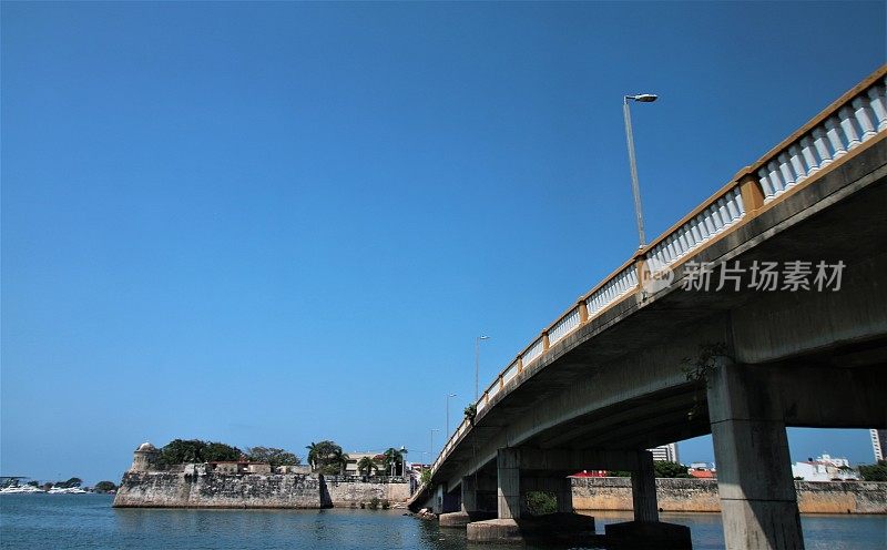 卡塔赫纳第25街桥横跨圣拉萨罗泻湖，桥的另一边有历史悠久的防御墙环绕着格塞马尼城区。