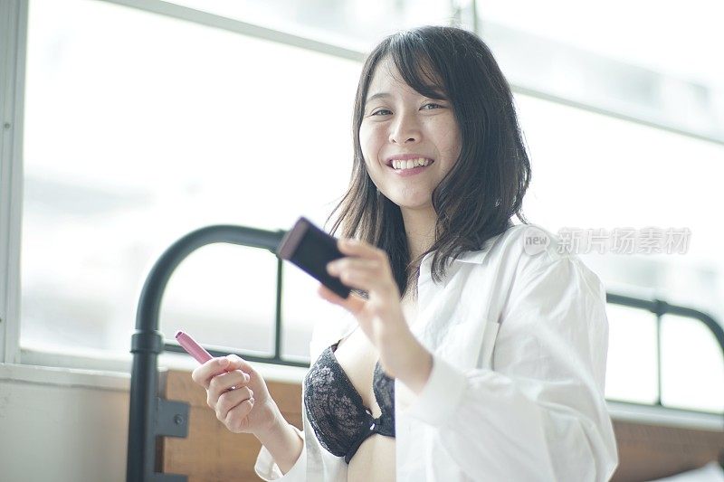 年轻女子在床上涂口红