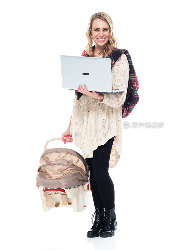 可爱的年轻妈妈抱着婴儿汽车座椅-抱着笔记本电脑