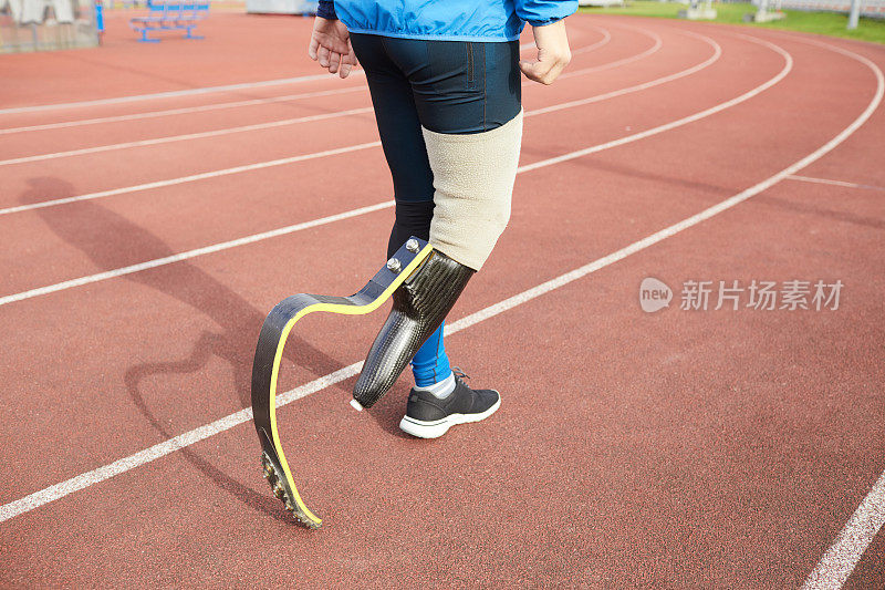 特写的男子短跑运动员与假肢的右腿走在体育场的户外