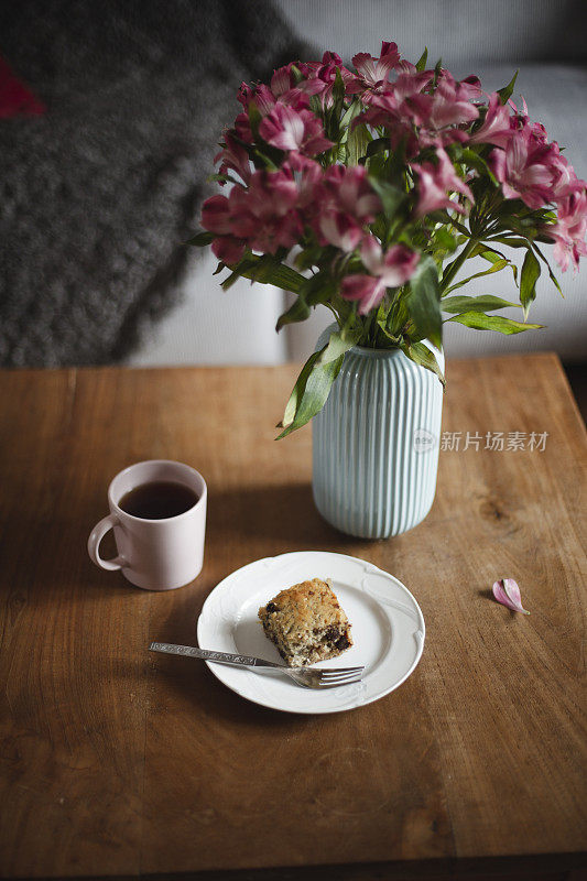 桌子上有蛋糕、咖啡和鲜花