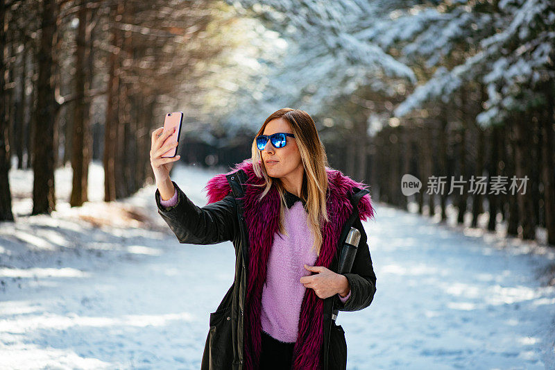 美丽的女人在雪山里自拍