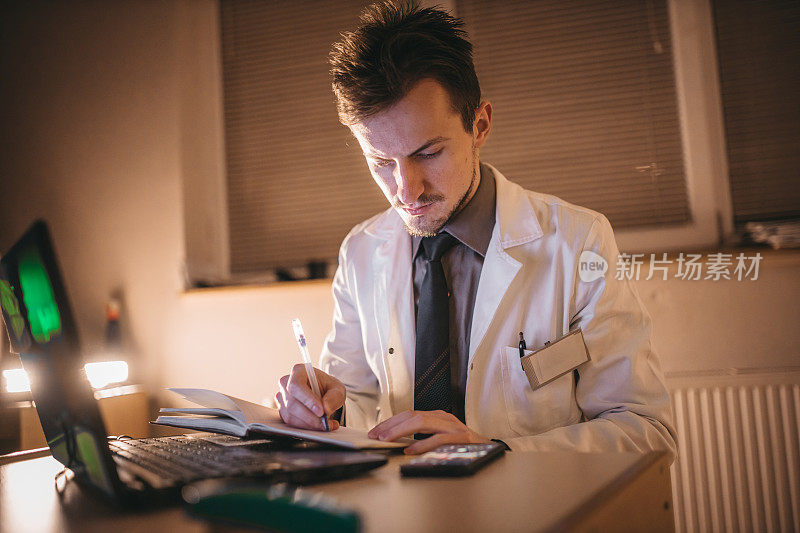 医生在办公室写医疗文件和使用笔记本电脑