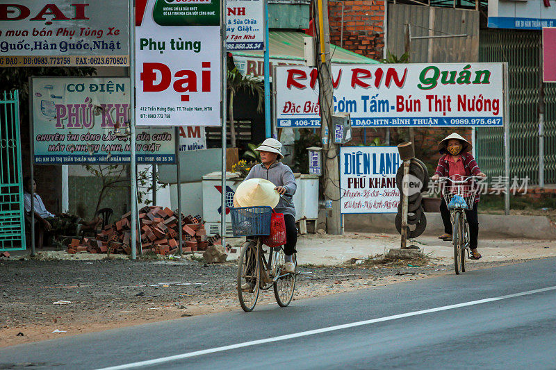 当地的越南人骑着自行车在路上运送货物。