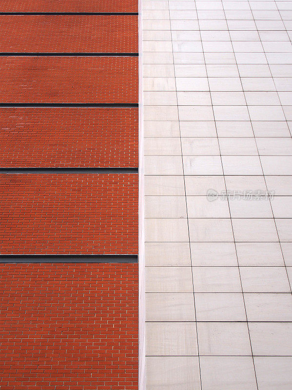 砖红砖砌成的墙，黑色线条被大块的白色现代石瓦分割成两半