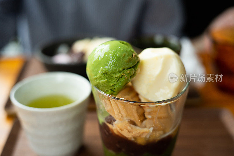 这是一款日式冻糕，在红豆沙上淋上绿茶冰淇淋和香草冰淇淋。