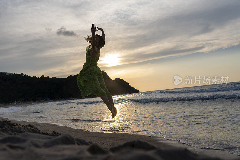 快乐的女人拿着帽子跑着跳着尽情享受海滩度假的生活。沙滩、夏日、liftstyle、积极心情、旅游、放松的概念。