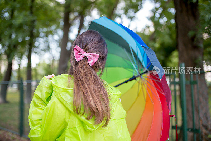 漂亮凉爽的女人带着五颜六色的雨伞在秋天的一天