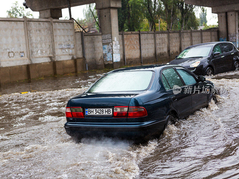乌克兰敖德萨——2016年9月20日:在暴雨引发的洪水中，在被淹没的道路上驾驶汽车。汽车漂浮在被水淹没的街道上。2016年9月20日发生在敖德萨的灾难。