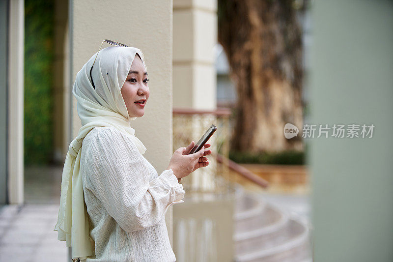 戴着头巾打电话的马来妇女