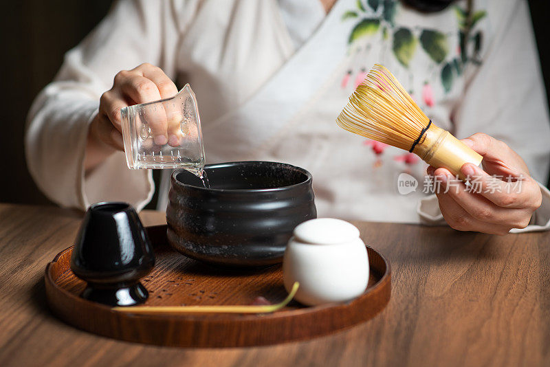 女人用传统的茶道用具制作抹茶绿茶