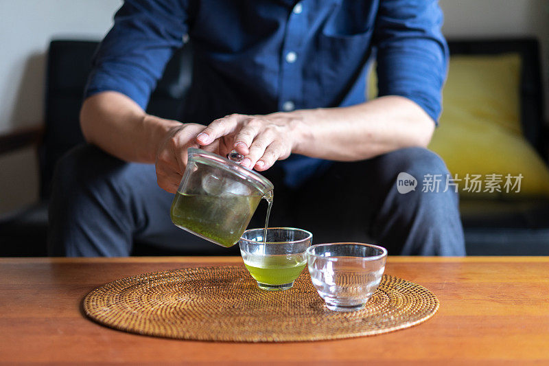 一个男人在自己家的客厅里泡日本茶
