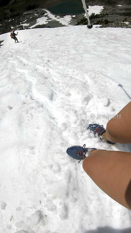 徒步旅行者沿着积雪的山坡跑下去