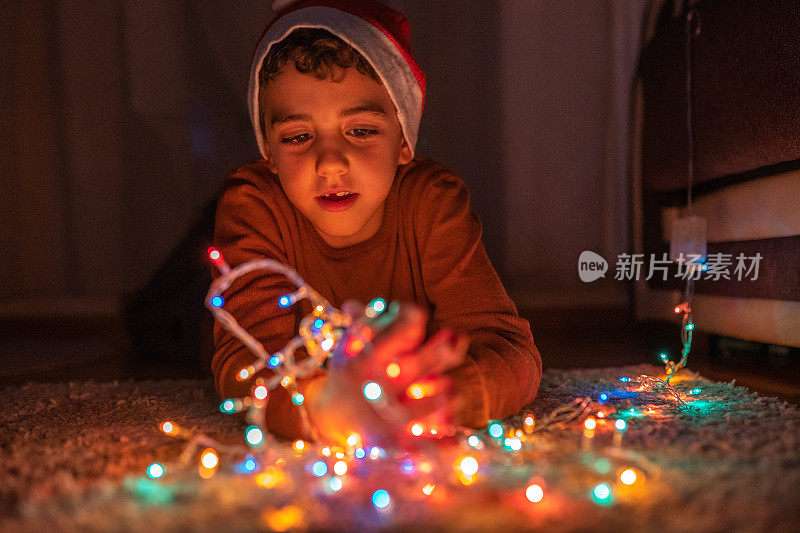 男孩在家里玩圣诞彩灯