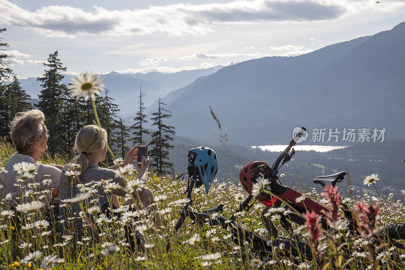 一对夫妇骑着山地电动自行车在高山草地的野花中放松