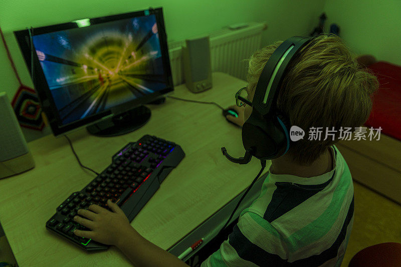 一个青少年玩电脑游戏的俯视图