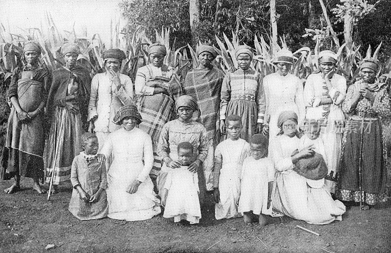 19世纪，南非祖鲁兰王国的一个Kraal村，穿着欧洲服装的AmaZulu妇女和女孩