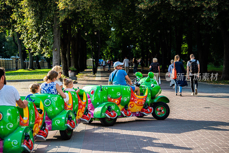 夏天，在基辅的马里因斯基公园，乌克兰的孩子们骑着毛毛虫车玩耍