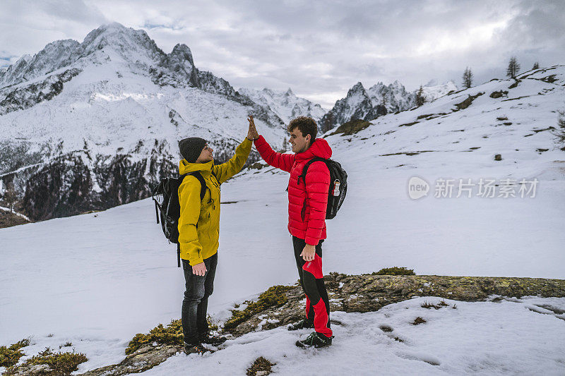 徒步旅行者在雪山的山脊上庆祝