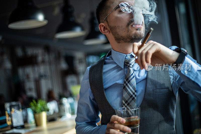 这位年轻的商人喜欢抽雪茄，享受权威和权力，喝威士忌，骄傲地环顾四周。