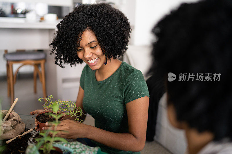 母亲和女儿在家里一起照料植物