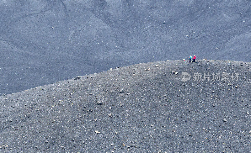 两名女子站在冰岛北部赫弗哈尔火山口的中心。