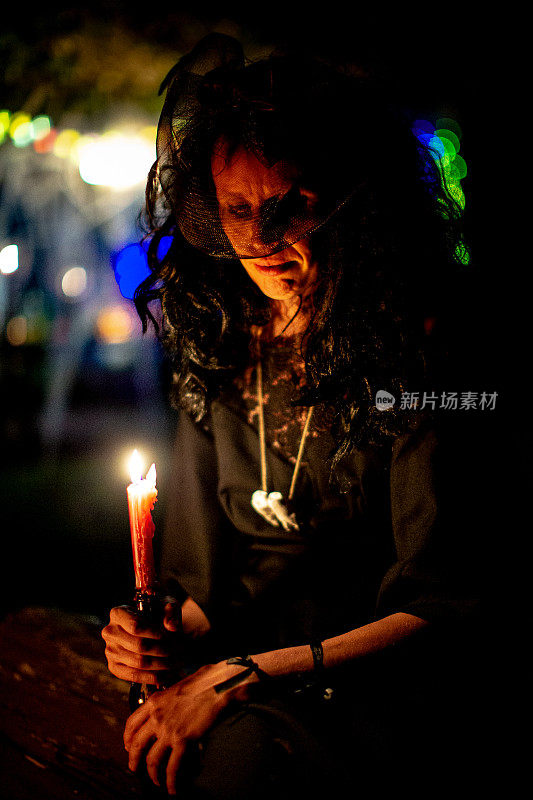 在万圣节的夜晚，拿着蜡烛的女巫肖像