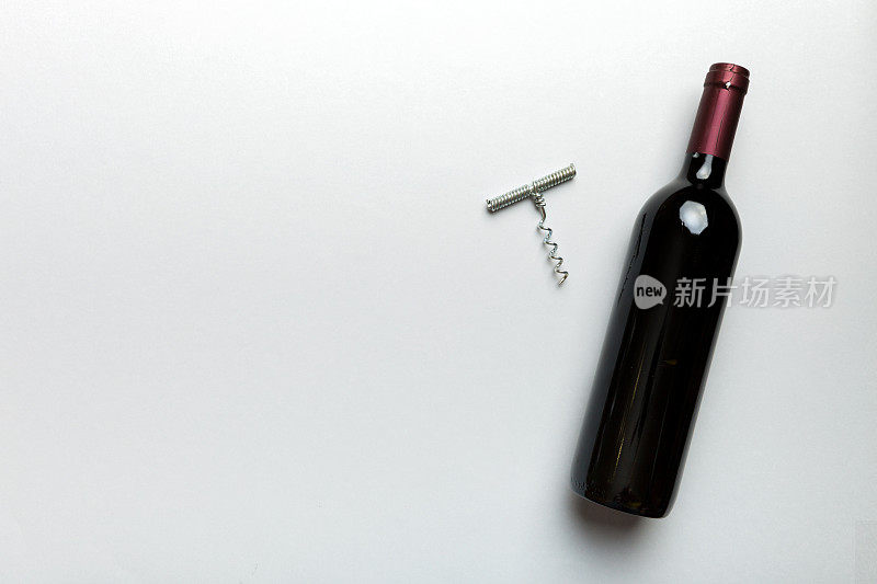 一瓶带开塞钻的红酒放在彩色桌子上。平躺，顶视图与复制空间