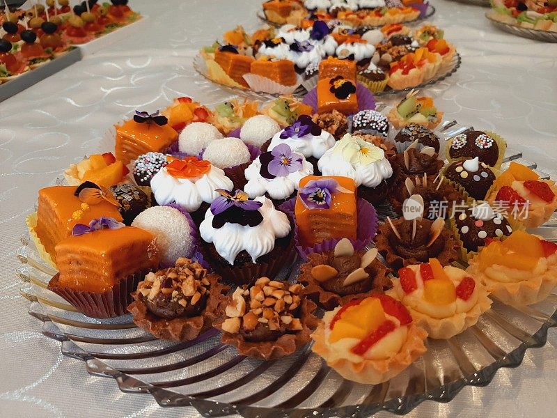 在一家大饭店里，宴会桌上摆满了香甜可口的饼干、纸杯蛋糕和松饼。
