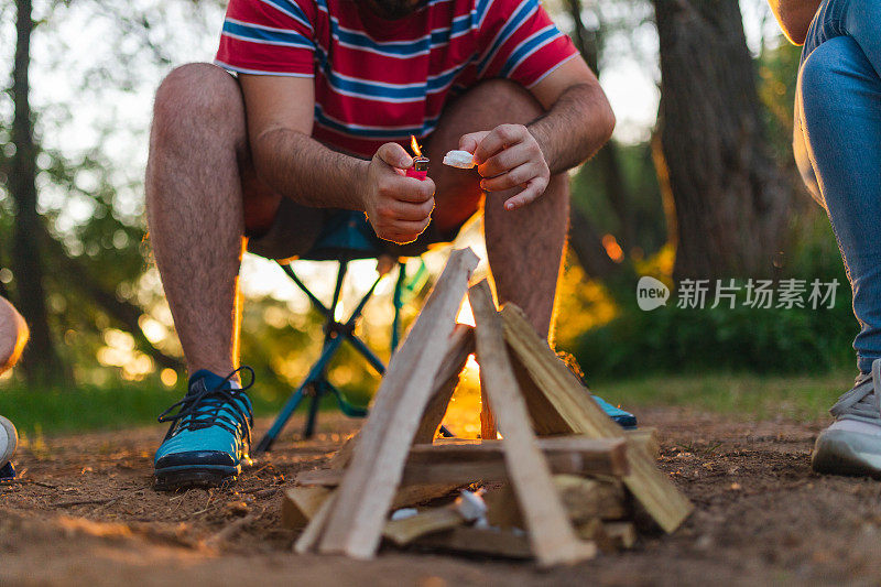 一个年轻人在野外与朋友露营时生火的特写镜头