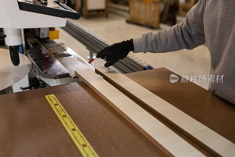 木材工厂的工人测量和切割木贴面板