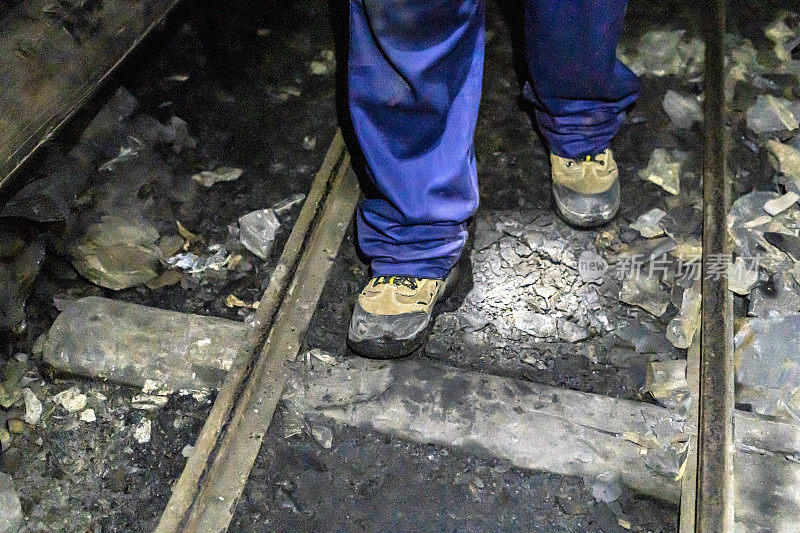 地铁矿井中一个矿工的脚的特写。