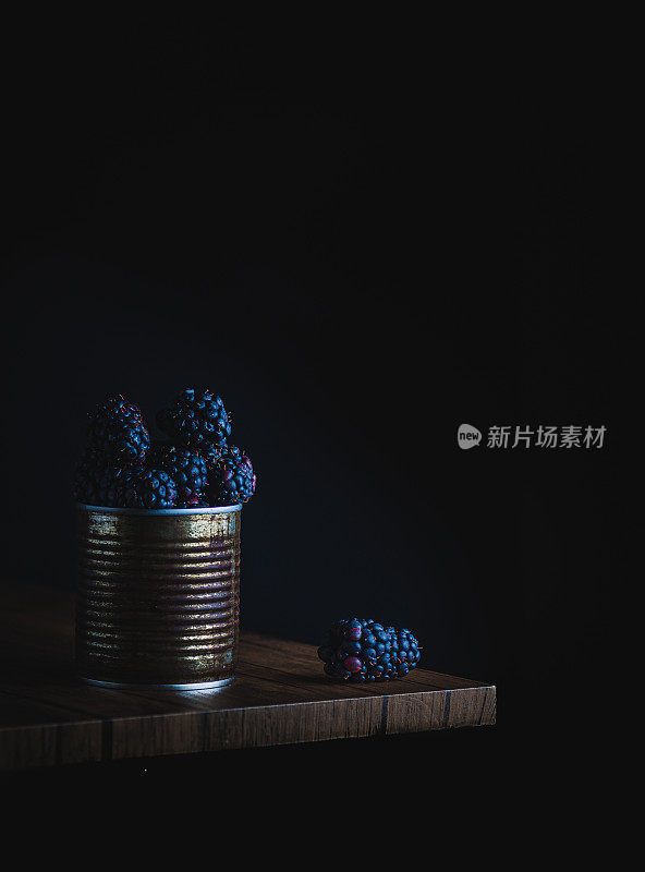 大黑莓的照片在生锈的锡上的木桌与黑暗的背景，复制空间