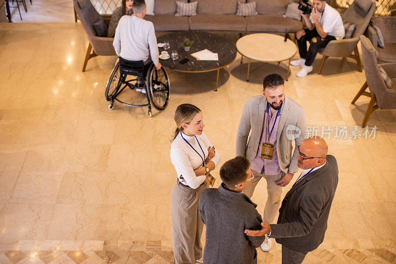 商务会议的参与者在会议开始前在酒店的大厅里进行社交活动