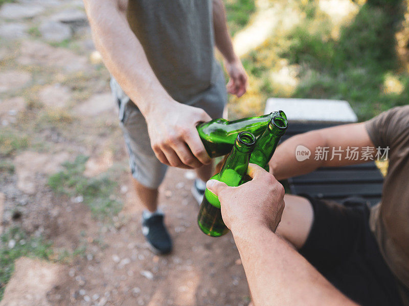 两个男人在大自然中碰杯，欢呼，举杯庆祝