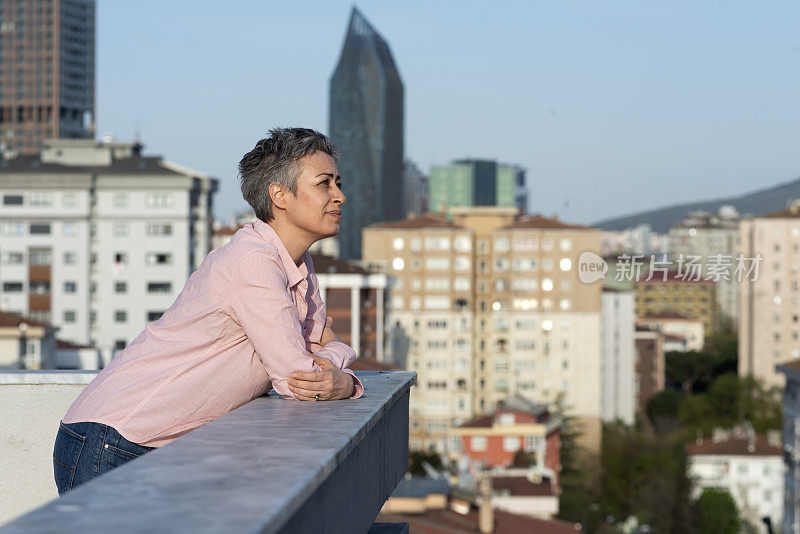 一个女人从屋顶上看城市的景色