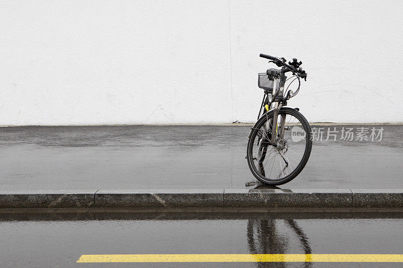 自行车在潮湿的人行道上有复制空间