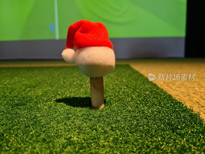 高尔夫球，戴着圣诞老人的红帽子。以圣诞新年为主题的运动理念