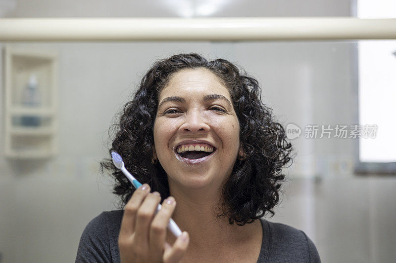 拉丁女人在浴室里愉快地刷牙