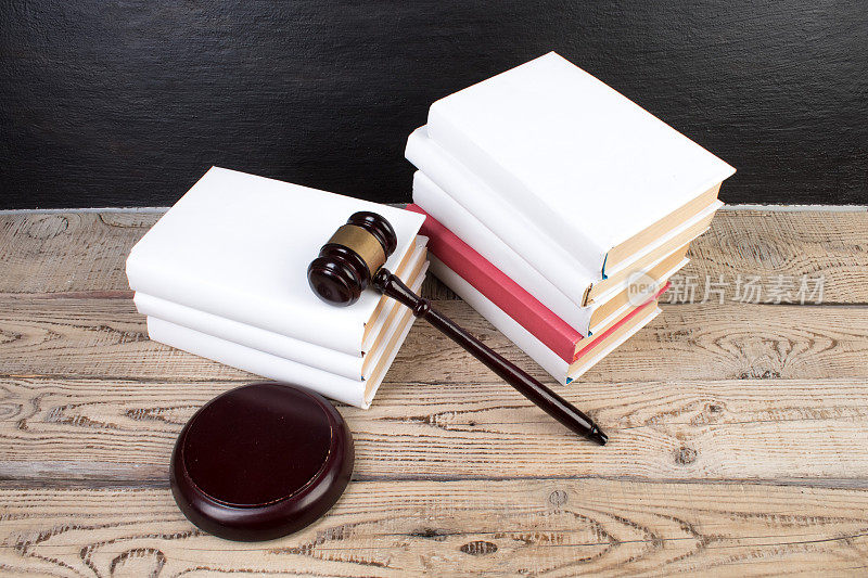 法律概念-在法庭或执法办公室的桌子上打开一本法律书，上面放着一个木制的法官木槌，背景是白色的。文本的复制空间。