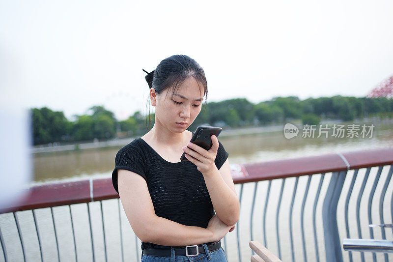 亚洲妇女在户外使用手机