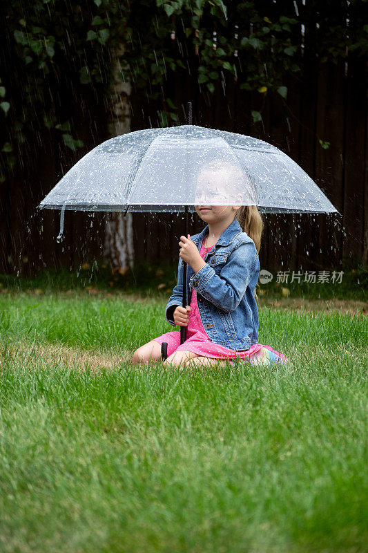 小女孩在雨中撑着伞