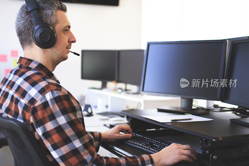 客户支持，呼叫中心和在电脑上工作的人的肖像，坐在办公室的桌子上，戴着带麦克风的耳机微笑