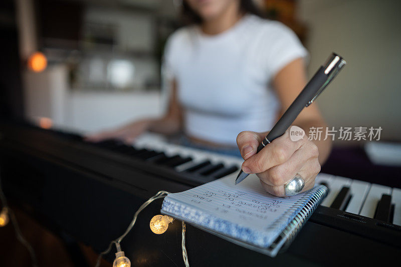 一个女人为合成器作曲的特写